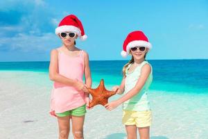 adorables niñas en vacaciones navideñas en la playa. foto