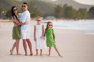 Happy family with kids walk on the beach at sunset photo