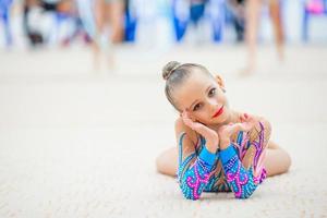 Beautiful little gymnast training on the carpet and ready for competitions photo