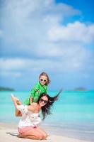 hermosa madre e hija en la playa caribeña disfrutando de las vacaciones de verano. foto