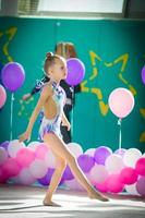 adorable gimnasta participa en competiciones de gimnasia rítmica foto