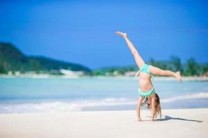 Adorable little girl at beach having a lot of fun in shallow water photo