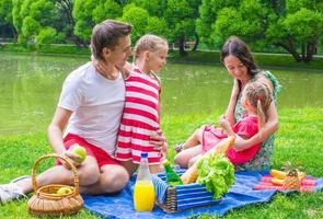 familia joven feliz haciendo un picnic al aire libre foto