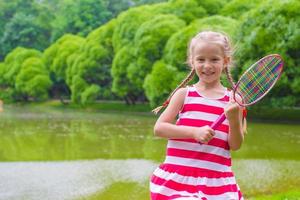 linda niña jugando al bádminton en un picnic foto