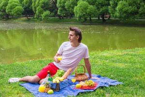 Young man picnicking and relaxing in the park photo