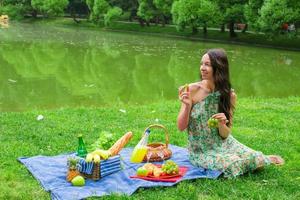 joven mujer feliz haciendo un picnic y relajándose al aire libre foto