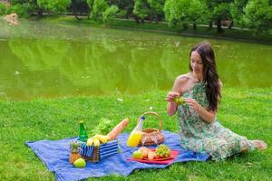 joven mujer feliz haciendo un picnic y relajándose al aire libre foto