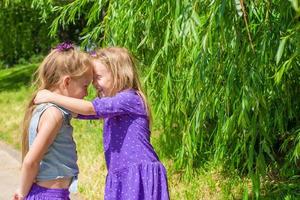 Happy adorable little girls enjoy summer day in the park photo