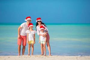 Happy family with two kids in Santa Hat on summer vacation photo