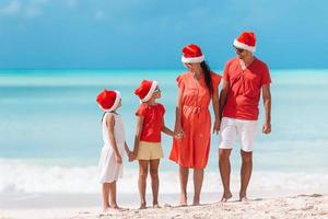 Happy family with two kids in Santa Hat on summer vacation photo