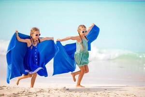 Little girls having fun enjoying vacation on tropical beach photo