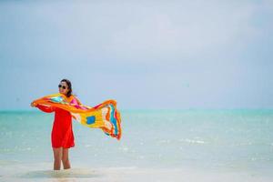 Young beautiful woman having fun on tropical seashore. Happy girl background the blue sky and turquoise water in the sea on caribbean island photo