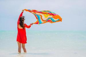 Young beautiful woman having fun on tropical seashore. Happy girl background the blue sky and turquoise water in the sea on caribbean island photo