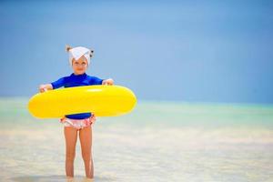 Happy kid with inflatable rubber circle having fun on the beach photo