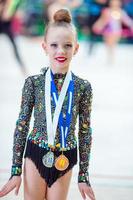 hermosa pequeña gimnasta entrenando en la alfombra y lista para las competiciones foto