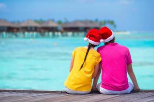 pareja con sombreros de santa en una playa tropical en maldivas foto