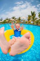 Happy kid with inflatable rubber circle having fun on the beach photo