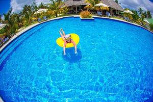 Happy kid with inflatable rubber circle having fun on the beach photo