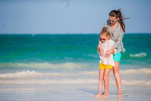 Beautiful mother and daughter at the beach enjoying summer vacation. photo