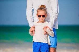 niña y papá feliz divirtiéndose durante las vacaciones en la playa foto