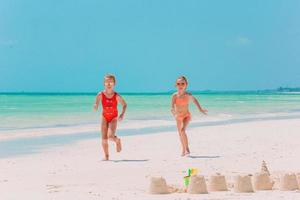 dos niñas felices se divierten mucho en la playa tropical jugando juntas foto