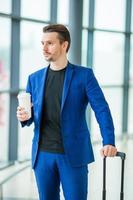 Young man in airport. Casual guy with luggage in international airport photo