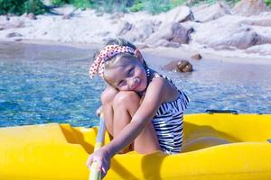 hermosa niña linda en kayak en el mar azul claro foto