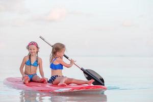 niñas nadando en tablas de surf durante las vacaciones de verano foto