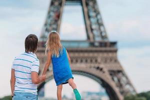 Little cute girl and her father in Paris near Eiffel Tower during summer french vacation photo