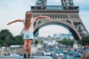 Adorable toddler girl in Paris background the Eiffel tower during summer vacation photo