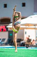 Adorable little girl swimming at outdoor swimming pool photo