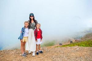 hermosa familia feliz en las montañas en el fondo de la niebla. hermoso paisaje foto