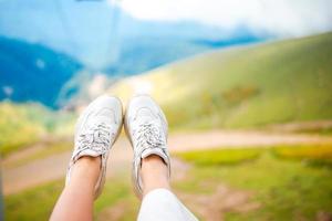 primer plano de piernas femeninas en zapatillas de deporte en el césped al aire libre en el parque foto