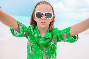 niña feliz tomando selfie en una playa tropical en una isla exótica foto