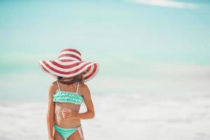 Cute little girl in hat at beach during caribbean vacation