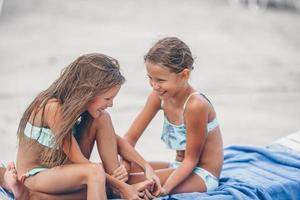 Little girls having fun at tropical beach playing together photo