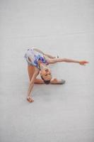 hermosa niña gimnasta activa con su actuación en la alfombra foto