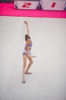 Beautiful little active gymnast girl with her performance on the carpet photo