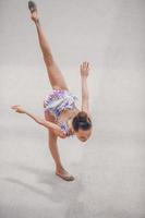 Beautiful little active gymnast girl with her performance on the carpet photo