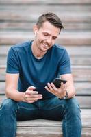 Man is reading text message on mobile phone while walking in the park photo