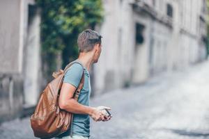 Boy caucasian with smartphone walking in street at Europe photo