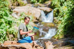 Man enjoying view of waterfall in gungle photo