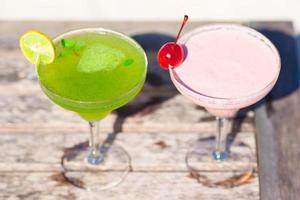 Two tasty cocktails on wooden table at tropical white beach photo