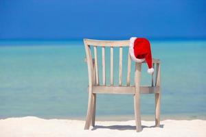 Red santa hat on beach chair at tropical vacation photo