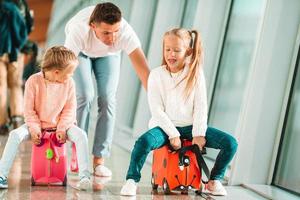 Happy family with two kids in airport have fun waiting for boarding photo