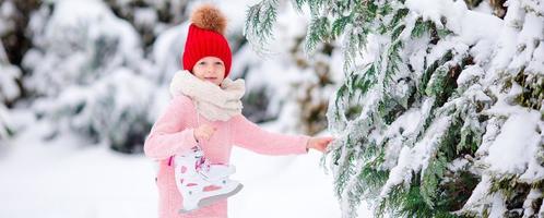 Cute little kid girl is going skate outdoors. photo