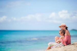 Little cute girl and young mother at tropical beach photo