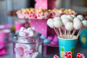 Marshmallow, sweet colored meringues, popcorn, custard cakes and cake pops on table photo