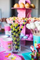 Canape of fruit, white chocolate cake pops and popcorn on sweet children's table at birthday party photo