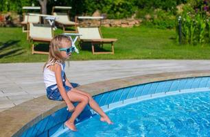 Adorable happy little girl in the swimming pool photo